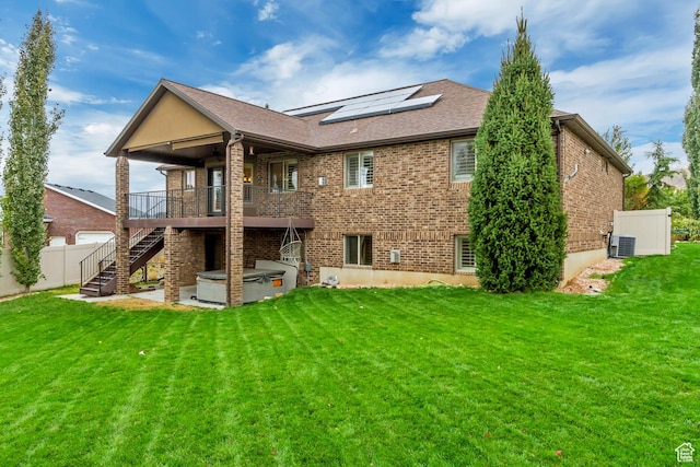 995 W 2650 S, Perry, UT 84302 - rear view of house featuring a hot tub, stairs, solar panels, and brick siding