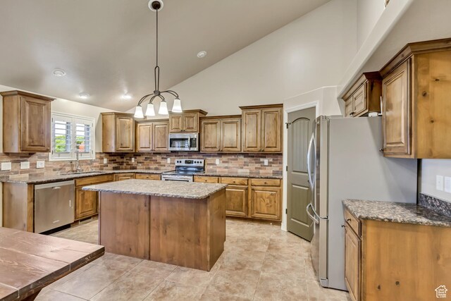 995 W 2650 S, Perry, UT 84302 - kitchen featuring appliances with stainless steel finishes, a sink, tasteful backsplash, brown cabinets, and high vaulted ceiling