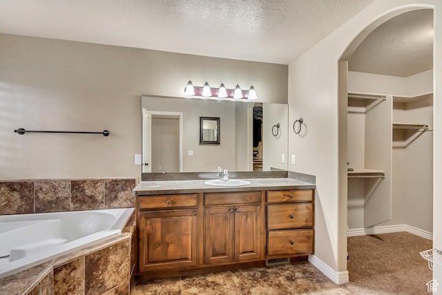 995 W 2650 S, Perry, UT 84302 - full bathroom featuring vanity, a walk in closet, a bath, and a textured ceiling