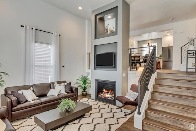 11211 S Clear Blue Dr, South Jordan, UT 84009 - living room with wood finished floors, stairs, a glass covered fireplace, and recessed lighting