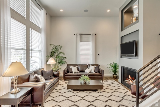 11211 S Clear Blue Dr, South Jordan, UT 84009 - living area with healthy amount of natural light, wood finished floors, a glass covered fireplace, baseboards, and recessed lighting