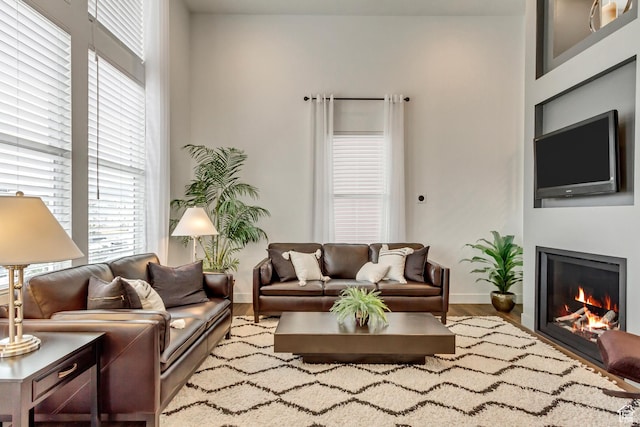 11211 S Clear Blue Dr, South Jordan, UT 84009 - living room with wood finished floors, a warm lit fireplace, and baseboards