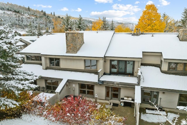 snow covered property featuring a chimney