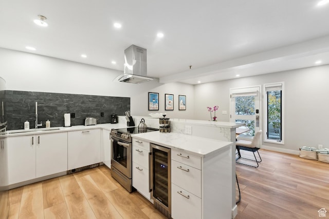 kitchen featuring a sink, beverage cooler, a peninsula, island exhaust hood, and stainless steel electric stove