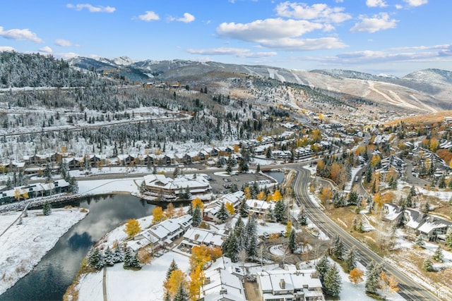 snowy aerial view with a residential view and a water and mountain view