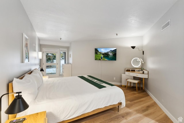 bedroom featuring visible vents, light wood-style flooring, baseboards, and access to outside