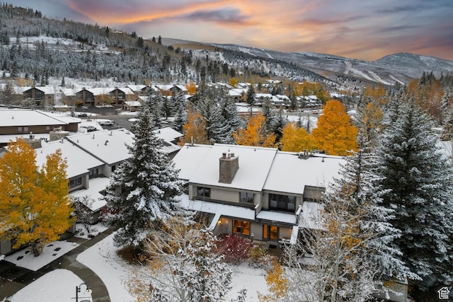 snowy aerial view featuring a residential view and a mountain view