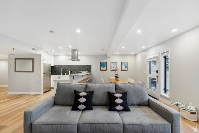 living room featuring light wood-type flooring, recessed lighting, baseboards, and visible vents