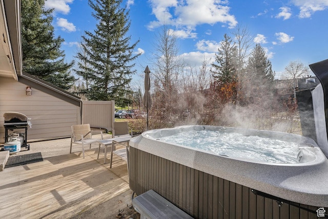 deck with a hot tub and a grill