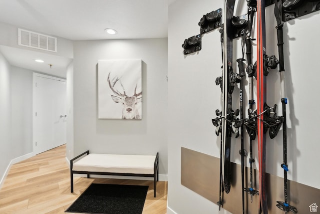 corridor with baseboards, recessed lighting, wood finished floors, and visible vents