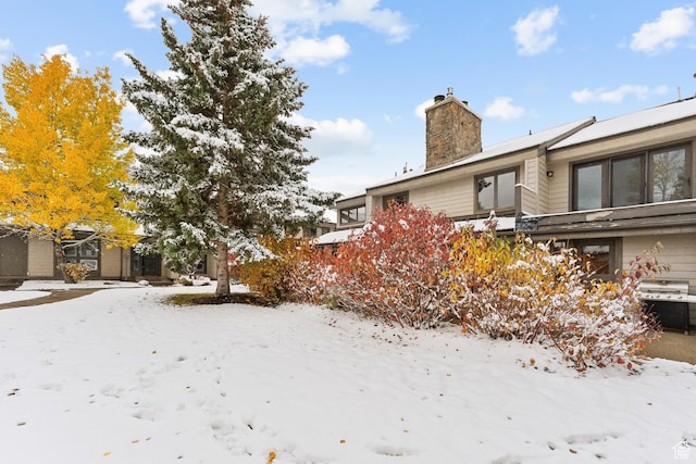 view of snow covered exterior featuring a chimney