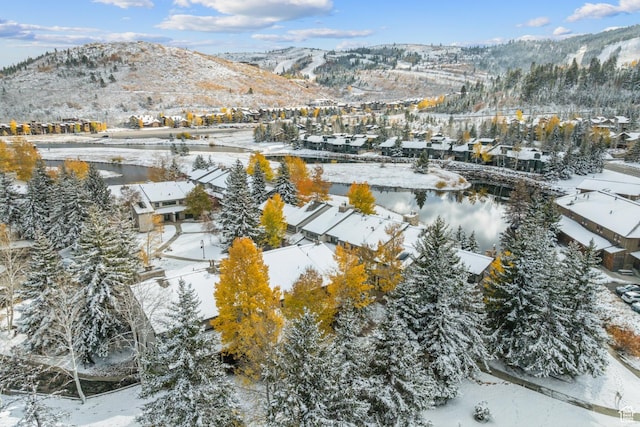 snowy aerial view featuring a mountain view and a residential view