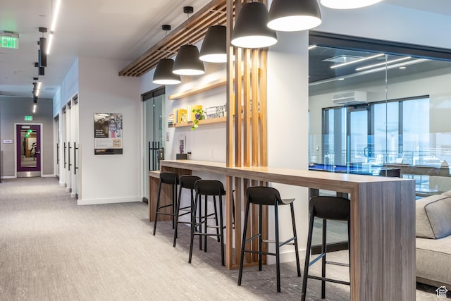 2670 W Canyons Resort Dr Unit 436, Park City, UT 84098 - kitchen with baseboards, a wall mounted AC, a kitchen bar, carpet flooring, and pendant lighting