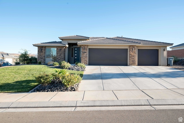 prairie-style home featuring a garage and a front lawn