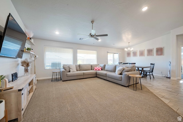 living room featuring ceiling fan with notable chandelier, light hardwood / wood-style flooring, lofted ceiling, and a textured ceiling