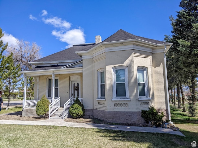114 E Main St, Moroni, UT 84646 - view of front of house with brick siding, a chimney, a porch, and a shingled roof