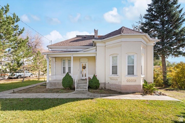 114 E Main St, Moroni, UT 84646 - view of front facade with a porch, a front yard, roof with shingles, and brick siding