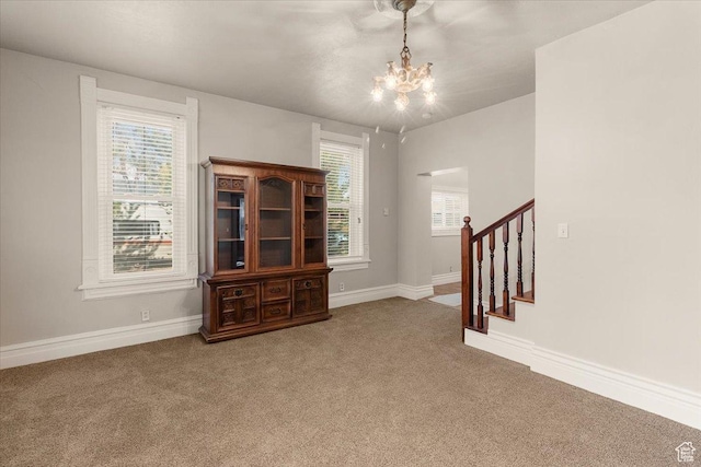 114 E Main St, Moroni, UT 84646 - unfurnished living room with a chandelier, carpet flooring, stairs, and healthy amount of natural light