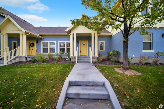 ranch-style home featuring roof with shingles, a front lawn, and stucco siding