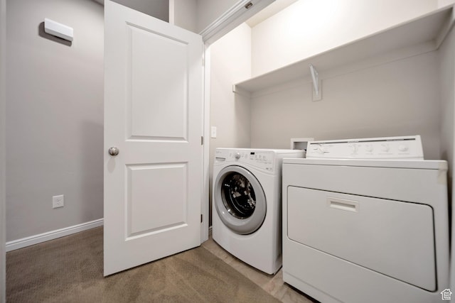 laundry room featuring washing machine and clothes dryer, laundry area, and light carpet