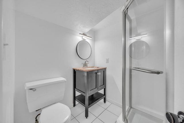 bathroom featuring toilet, tile patterned flooring, vanity, a textured ceiling, and walk in shower