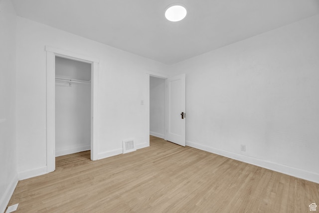 unfurnished bedroom with a closet and light hardwood / wood-style flooring