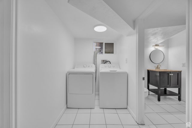 washroom with light tile patterned floors and washer and clothes dryer
