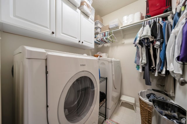 washroom featuring washer and clothes dryer and cabinets