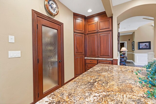 301 S Rachel Ln, New Harmony, UT 84757 - kitchen featuring arched walkways and light stone counters