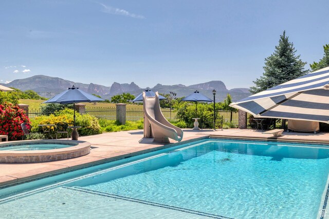301 S Rachel Ln, New Harmony, UT 84757 - view of swimming pool with a water slide, a mountain view, an in-ground hot tub, and fence