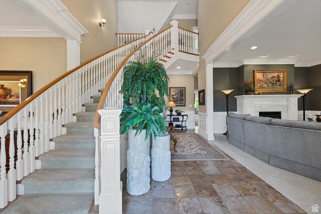 301 S Rachel Ln, New Harmony, UT 84757 - staircase with ornamental molding, a towering ceiling, a fireplace, recessed lighting, and wainscoting