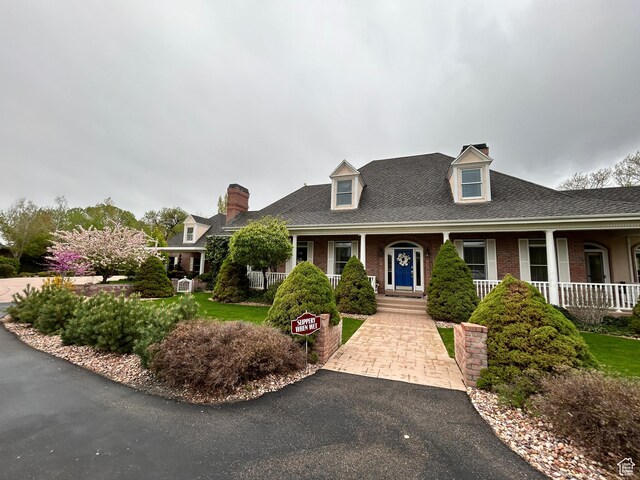 301 S Rachel Ln, New Harmony, UT 84757 - new england style home with a chimney, brick siding, a porch, and roof with shingles