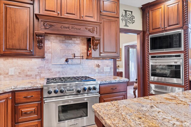 301 S Rachel Ln, New Harmony, UT 84757 - kitchen with stainless steel appliances, a warming drawer, light stone countertops, and brown cabinets