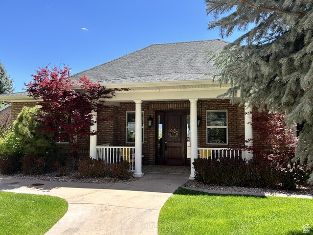 301 S Rachel Ln, New Harmony, UT 84757 - view of front facade featuring covered porch, brick siding, and a shingled roof