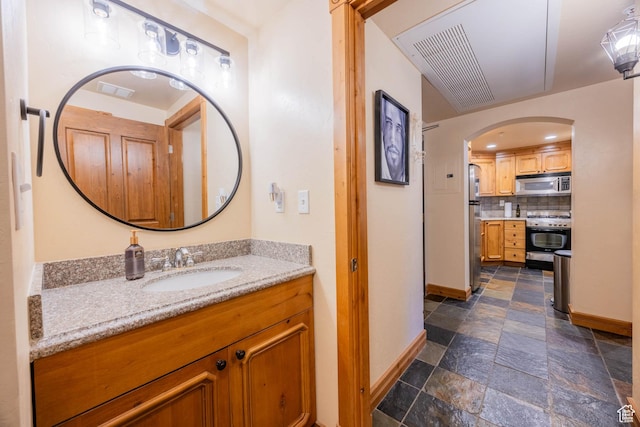 840 Bigler Ln Unit 2039, Midway, UT 84049 - bathroom featuring baseboards, stone tile flooring, decorative backsplash, and vanity