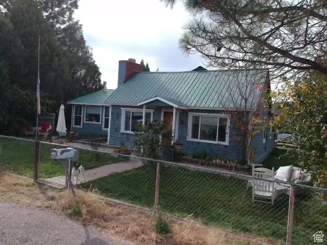 295 N 200 W, Monroe, UT 84754 - view of front of home with a front lawn, a fenced front yard, a chimney, and metal roof