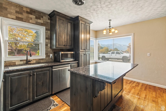 455 N 500 W, Richfield, UT 84701 - kitchen with stainless steel appliances, a sink, light wood finished floors, a chandelier, and dark stone countertops