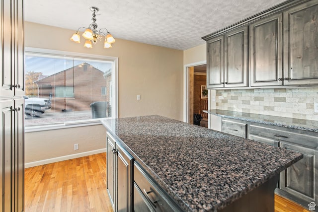 455 N 500 W, Richfield, UT 84701 - kitchen with a chandelier, light wood-style floors, backsplash, baseboards, and a center island