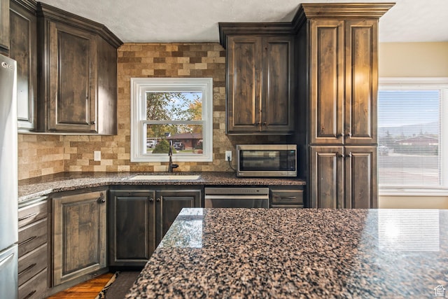 455 N 500 W, Richfield, UT 84701 - kitchen with appliances with stainless steel finishes, a sink, healthy amount of natural light, and dark stone counters