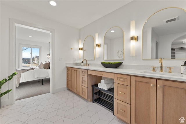 ensuite bathroom featuring double vanity and recessed lighting