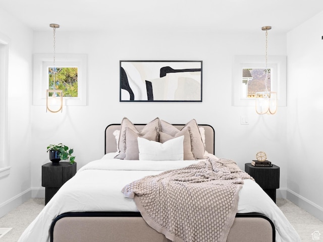 bedroom featuring baseboards, carpet flooring, and multiple windows