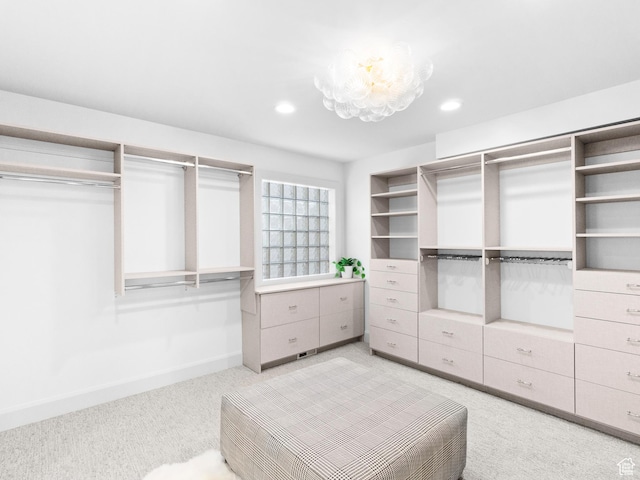 walk in closet featuring light colored carpet