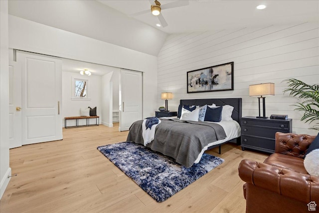 bedroom featuring light wood-style flooring, recessed lighting, wooden walls, high vaulted ceiling, and a ceiling fan