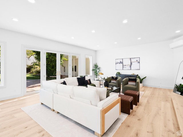 living area with light wood-style floors, recessed lighting, french doors, and an AC wall unit