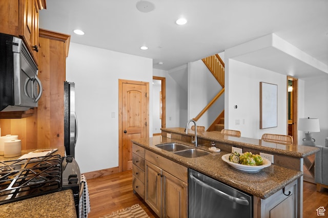 3025 Lower Saddleback Rd Unit 13, Park City, UT 84098 - kitchen featuring a breakfast bar, sink, light hardwood / wood-style flooring, stainless steel appliances, and a kitchen island with sink