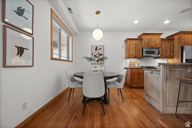 3025 Lower Saddleback Rd Unit 13, Park City, UT 84098 - kitchen featuring hanging light fixtures, tasteful backsplash, appliances with stainless steel finishes, and light hardwood / wood-style floors