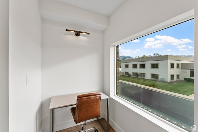 office area with plenty of natural light, baseboards, and wood finished floors