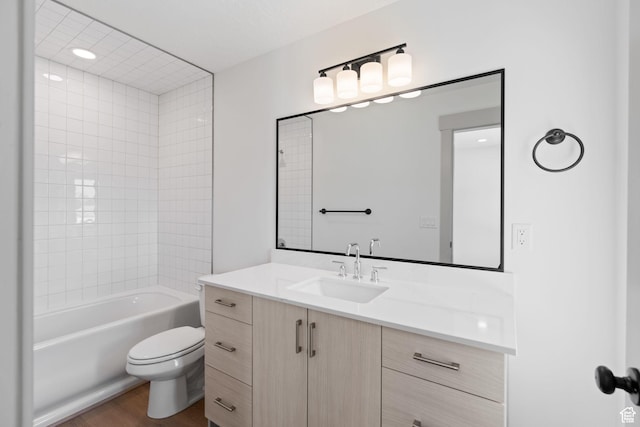 full bath with toilet, wood finished floors, vanity, and bathing tub / shower combination