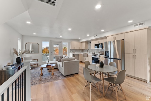 living room with light wood finished floors and recessed lighting