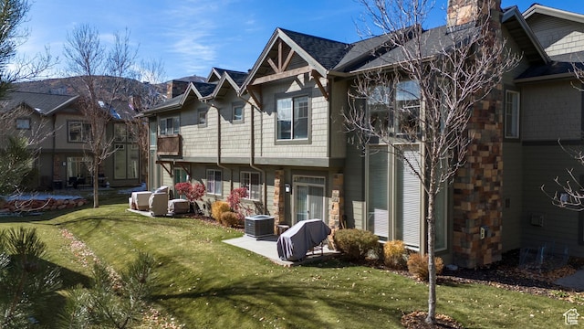 6042 N Fox Pointe Cir, Park City, UT 84098 - back of house with a chimney, a lawn, central AC, and stone siding
